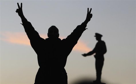 A supporter of the constitution gestures in front of a statue of Egypt's former Army Chief of Staff Abdel Moneim Riad near Tahrir square, du A supporter of the constitution gestures in front of a statue of Egypt's former Army Chief of Staff Abdel Moneim Riad near Tahrir square, du