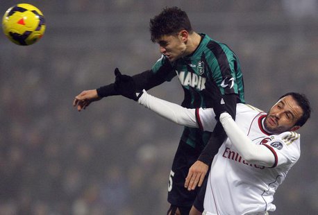 AC Milan's Giampaolo Pazzini (R) jumps for the ball with Sassuolo's Luca Antei during their Italian Serie A soccer match at the Mapei stadiu AC Milan's Giampaolo Pazzini (R) jumps for the ball with Sassuolo's Luca Antei during their Italian Serie A soccer match at the Mapei stadiu