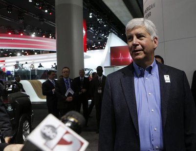 Michigan Governor Rick Snyder (R-MI) is interviewed as he tours the display floor during the press preview day of the North American Interna Michigan Governor Rick Snyder (R-MI) is interviewed as he tours the display floor during the press preview day of the North American Interna