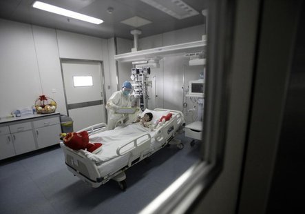 A girl infected with the new H7N9 bird flu strain draws a picture with a nurse at Ditan Hospital in Beijing, April 14, 2013. REUTERS/Suzie W A girl infected with the new H7N9 bird flu strain draws a picture with a nurse at Ditan Hospital in Beijing, April 14, 2013. REUTERS/Suzie W