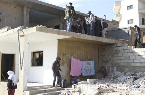 People inspect a site hit by rocket fire from Syria at the Lebanese border town of Arsal January 17, 2014. REUTERS/Ahmad Shalha People inspect a site hit by rocket fire from Syria at the Lebanese border town of Arsal January 17, 2014. REUTERS/Ahmad Shalha