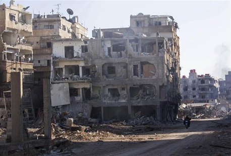 Men ride a motorbike past buildings damaged by what activists said was shelling by forces loyal to Syria's President Bashar al-Assad in Dara Men ride a motorbike past buildings damaged by what activists said was shelling by forces loyal to Syria's President Bashar al-Assad in Dara