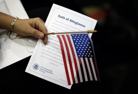 A woman holds the Oath of Allegiance at a naturalization ceremony for 3,703 new U.S. citizens from 130 countries, in Los Angeles, California A woman holds the Oath of Allegiance at a naturalization ceremony for 3,703 new U.S. citizens from 130 countries, in Los Angeles, California
