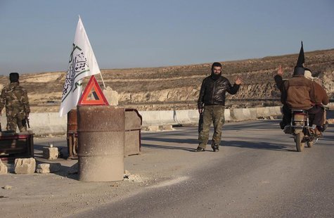 A member of al-Jabha al-Islamiya (the Islamic Front) mans a checkpoint between the village of Kafaroumeh and the town of Maaret al-Naaman, t A member of al-Jabha al-Islamiya (the Islamic Front) mans a checkpoint between the village of Kafaroumeh and the town of Maaret al-Naaman, t