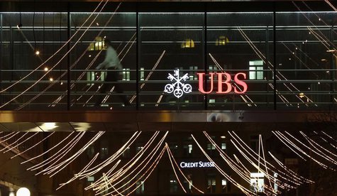 A man walks past the logo of Swiss Bank UBS on a footbridge connecting two office buildings in Zurich December 19, 2013. REUTERS/Arnd Wiegma A man walks past the logo of Swiss Bank UBS on a footbridge connecting two office buildings in Zurich December 19, 2013. REUTERS/Arnd Wiegma