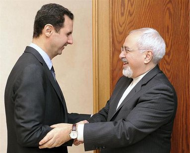 Syria's President Bashar al-Assad (L) welcomes Iran's Foreign Minister Mohammad Javad Zarif before a meeting in Damascus January 15, 2014, i Syria's President Bashar al-Assad (L) welcomes Iran's Foreign Minister Mohammad Javad Zarif before a meeting in Damascus January 15, 2014, i