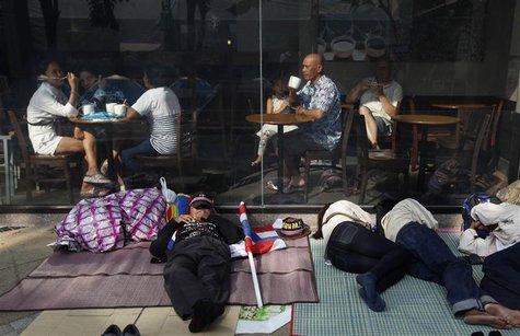 Anti-government protesters sleep in front of a coffee shop in central Bangkok January 20, 2014. REUTERS/Paul Barker Anti-government protesters sleep in front of a coffee shop in central Bangkok January 20, 2014. REUTERS/Paul Barker