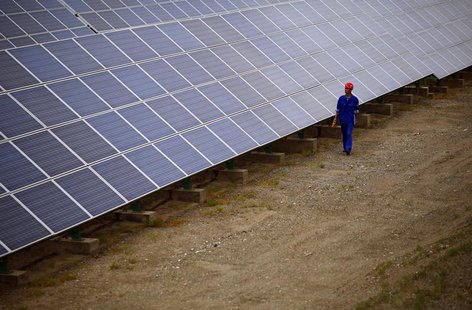 A worker inspects solar panels at a solar farm in Dunhuang, 950km (590 miles) northwest of Lanzhou, Gansu Province September 16, 2013. 26.RE A worker inspects solar panels at a solar farm in Dunhuang, 950km (590 miles) northwest of Lanzhou, Gansu Province September 16, 2013. 26.RE
