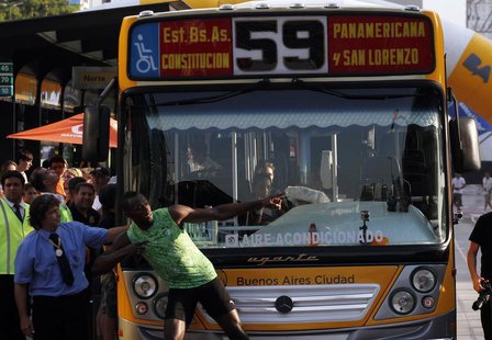 Jamaican sprinter Usain Bolt poses next to the bus driver after competing in a race against a public bus during a demonstration event in Bue Jamaican sprinter Usain Bolt poses next to the bus driver after competing in a race against a public bus during a demonstration event in Bue