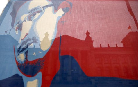 The Reichstag building, seat of the German lower house of parliament Bundestag, is pictured though a flag depicting fugitive former U.S. Nat The Reichstag building, seat of the German lower house of parliament Bundestag, is pictured though a flag depicting fugitive former U.S. Nat