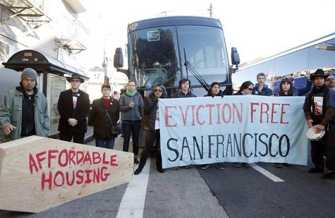 Protesters block a bus full of Apple employees during a protest against rising costs of living in San Francisco, California, December 20, 20 Protesters block a bus full of Apple employees during a protest against rising costs of living in San Francisco, California, December 20, 20
