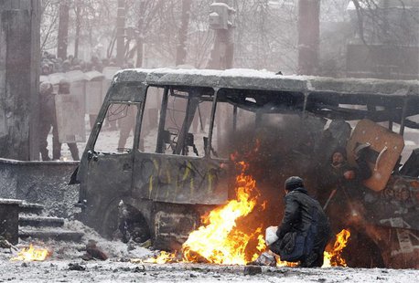 Pro-European protesters take cover behind a burnt bus during clashes with riot police in Kiev January 22, 2014. REUTERS/Vasily Fedosenko Pro-European protesters take cover behind a burnt bus during clashes with riot police in Kiev January 22, 2014. REUTERS/Vasily Fedosenko
