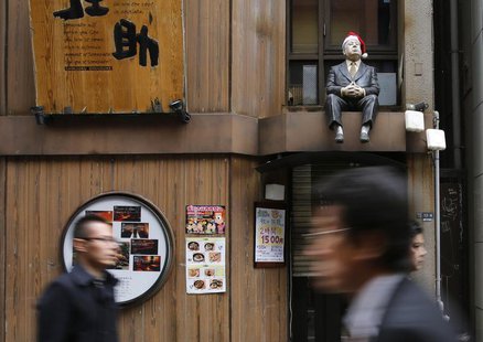 A lifesized doll, adorned with a Santa hat, is seen above the doorway of a restaurant as people walk along a street at Tokyo's Shinjuku shop A lifesized doll, adorned with a Santa hat, is seen above the doorway of a restaurant as people walk along a street at Tokyo's Shinjuku shop