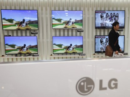 A customer talks in front of LG 3D TV sets which are made with LG Display flat screens, at a store in Seoul January 23, 2013. REUTERS/Kim Ho A customer talks in front of LG 3D TV sets which are made with LG Display flat screens, at a store in Seoul January 23, 2013. REUTERS/Kim Ho