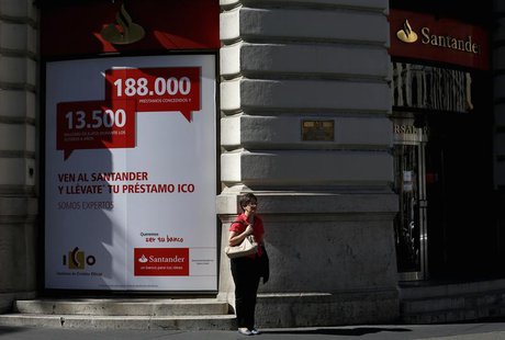 A woman stands outside a Santander bank branch in Madrid October 11, 2013. REUTERS/Juan Medina A woman stands outside a Santander bank branch in Madrid October 11, 2013. REUTERS/Juan Medina
