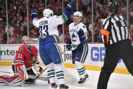 Dec 20, 2013; Chicago, IL, USA; Vancouver Canucks left wing Daniel Sedin (22) celebrates with center Henrik Sedin (33) after scoring a goal Dec 20, 2013; Chicago, IL, USA; Vancouver Canucks left wing Daniel Sedin (22) celebrates with center Henrik Sedin (33) after scoring a goal