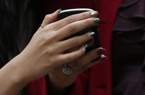 Two women look at a mobile phone on Oxford Street in London October 29, 2012. REUTERS/Suzanne Plunkett Two women look at a mobile phone on Oxford Street in London October 29, 2012. REUTERS/Suzanne Plunkett