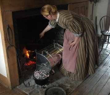 A Wade House volunteer checks the food cooking for the Hearthside Dinner. A Wade House volunteer checks the food cooking for the Hearthside Dinner.