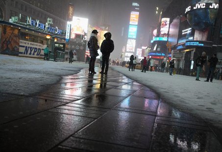 People stand on a heated section of pavement as it snows in Times Square in New York, January 3, 2014. REUTERS/Carlo Allegri People stand on a heated section of pavement as it snows in Times Square in New York, January 3, 2014. REUTERS/Carlo Allegri