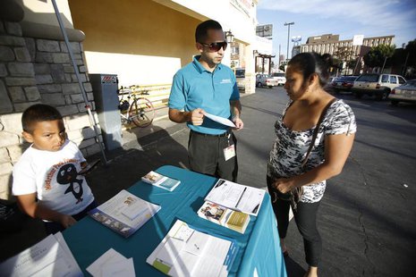 Jaime Corona, patient care coordinator at AltaMed, speaks to a woman during a community outreach on Obamacare in Los Angeles, California Nov Jaime Corona, patient care coordinator at AltaMed, speaks to a woman during a community outreach on Obamacare in Los Angeles, California Nov