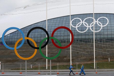 Volunteers walk along of the Olympic rings in front of the Bolshoy Ice Dome at the Olympic Park, in the Adler district of Sochi, January 24, Volunteers walk along of the Olympic rings in front of the Bolshoy Ice Dome at the Olympic Park, in the Adler district of Sochi, January 24,