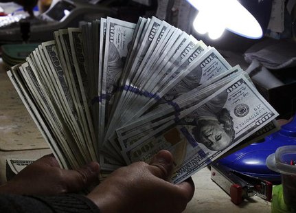 A money changer inspects U.S. dollar bills at a currency exchange in Manila January 15, 2014. REUTERS/Romeo Ranoco A money changer inspects U.S. dollar bills at a currency exchange in Manila January 15, 2014. REUTERS/Romeo Ranoco