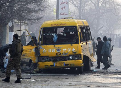 Afghan policemen inspect the wreckage of a bus hit by a suicide attack in Kabul January 26, 2014. A suicide bomber attacked an Afghan army b Afghan policemen inspect the wreckage of a bus hit by a suicide attack in Kabul January 26, 2014. A suicide bomber attacked an Afghan army b