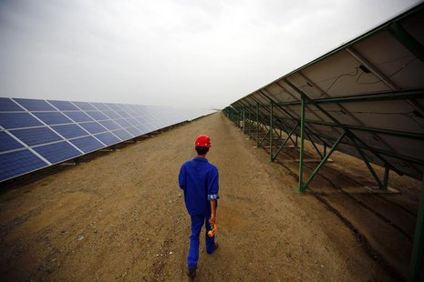 A worker inspects solar panels at a solar farm in Dunhuang, 950km (590 miles) northwest of Lanzhou, Gansu Province September 16, 2013. REUTE A worker inspects solar panels at a solar farm in Dunhuang, 950km (590 miles) northwest of Lanzhou, Gansu Province September 16, 2013. REUTE