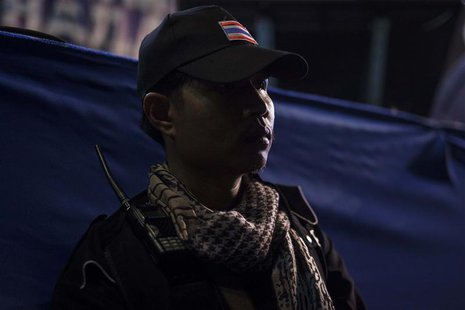 A guard from the anti-government protesters guards the stage as protest leader Suthep Thaugsuban speaks to his supporters during a rally in A guard from the anti-government protesters guards the stage as protest leader Suthep Thaugsuban speaks to his supporters during a rally in