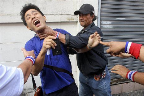 Anti-government protesters attack a voter near a polling station in Bangkok January 26, 2014. REUTERS/Stringer Anti-government protesters attack a voter near a polling station in Bangkok January 26, 2014. REUTERS/Stringer