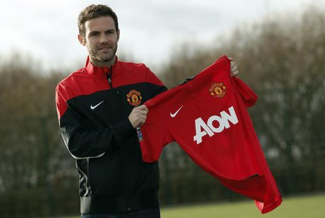 Manchester United's new signing Juan Mata holds a club shirt during a photocall at the club's Carrington training complex in Manchester, nor Manchester United's new signing Juan Mata holds a club shirt during a photocall at the club's Carrington training complex in Manchester, nor