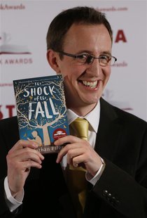 Shortlisted author Nathan Filer poses for a photograph with his book "The shock of the Fall" before the announcement of the winner of the Co Shortlisted author Nathan Filer poses for a photograph with his book "The shock of the Fall" before the announcement of the winner of the Co