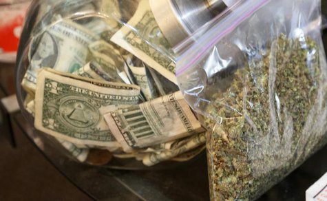 A bag of marijuana being prepared for sale sits next to a money jar at BotanaCare in Northglenn, Colorado December 31, 2013. REUTERS/Rick Wi A bag of marijuana being prepared for sale sits next to a money jar at BotanaCare in Northglenn, Colorado December 31, 2013. REUTERS/Rick Wi