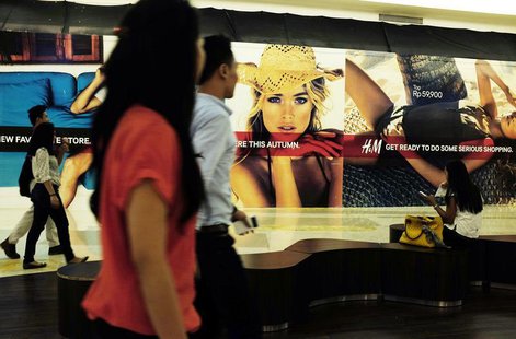 People walk in front of a billboard of a new store at a mall in Jakarta, September 4, 2013. REUTERS/Beawiharta People walk in front of a billboard of a new store at a mall in Jakarta, September 4, 2013. REUTERS/Beawiharta