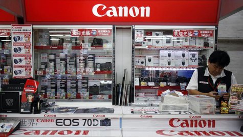 A shop staff works at Canon's camera booth at an electronic shop in Tokyo October 24, 2013. REUTERS/Yuya Shino A shop staff works at Canon's camera booth at an electronic shop in Tokyo October 24, 2013. REUTERS/Yuya Shino
