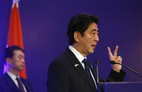 Japan's Prime Minister Shinzo Abe shows a sign as he speaks at a business meeting organised by Confederation of Indian Industry (CII) in New Japan's Prime Minister Shinzo Abe shows a sign as he speaks at a business meeting organised by Confederation of Indian Industry (CII) in New
