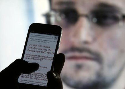A man uses his cell phone to read updates about former U.S. spy agency contractor Edward Snowden answering users' questions on Twitter in th A man uses his cell phone to read updates about former U.S. spy agency contractor Edward Snowden answering users' questions on Twitter in th