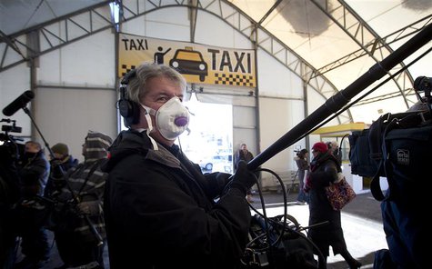 A member of the media wears a face mask as he holds a boom pole after Royal Caribbean's cruise ship, Explorer of the Seas arrived back at Ba A member of the media wears a face mask as he holds a boom pole after Royal Caribbean's cruise ship, Explorer of the Seas arrived back at Ba