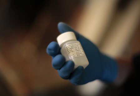 Orange County Deputy Probation Officer Erin Merritt holds a canister of methadone which she found in a former heroin-addict probationer's ap Orange County Deputy Probation Officer Erin Merritt holds a canister of methadone which she found in a former heroin-addict probationer's ap