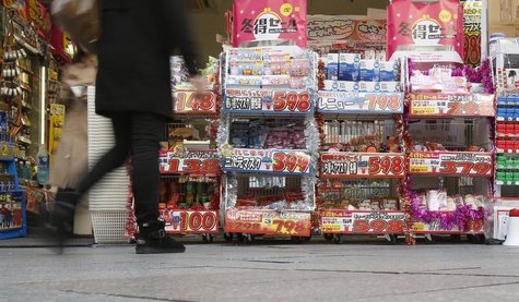 A pedestrian walk past a discount shop in Tokyo November 29, 2013. REUTERS/Yuya Shino A pedestrian walk past a discount shop in Tokyo November 29, 2013. REUTERS/Yuya Shino