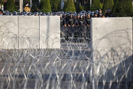 Riot police officers stand guard behind barricades as anti-government protesters rally outside the Thai Royal Police Club in Bangkok January Riot police officers stand guard behind barricades as anti-government protesters rally outside the Thai Royal Police Club in Bangkok January