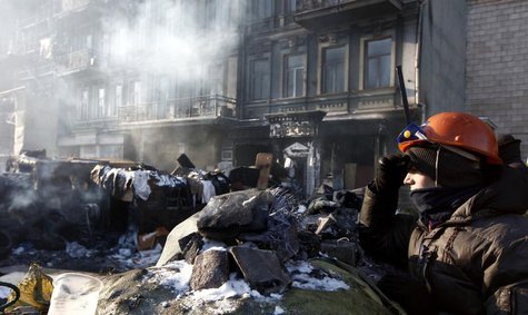 An anti-government protester, standing on a barricade, surveys a cordon of riot police as temperatures stand at minus 20 degrees Celsius (mi An anti-government protester, standing on a barricade, surveys a cordon of riot police as temperatures stand at minus 20 degrees Celsius (mi
