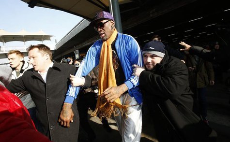 Bodyguards clear a path for former NBA basketball player Dennis Rodman (C) as journalists surround him upon his arrival from North Korea's P Bodyguards clear a path for former NBA basketball player Dennis Rodman (C) as journalists surround him upon his arrival from North Korea's P