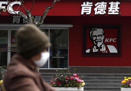 A woman, wearing a mask, rides past a KFC restaurant in Shanghai April 11, 2013. REUTERS/Aly Song A woman, wearing a mask, rides past a KFC restaurant in Shanghai April 11, 2013. REUTERS/Aly Song