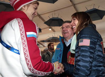 International Olympic Committee (IOC) President Thomas Bach smiles as Russia's ice hockey player Iya Gavrilova (L) and U.S speed skater Anna International Olympic Committee (IOC) President Thomas Bach smiles as Russia's ice hockey player Iya Gavrilova (L) and U.S speed skater Anna