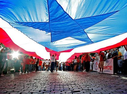 People march under a huge Puerto Rican flag in Old San Juan, Puerto Rico, October 8, 2006. REUTERS/Ana Martinez People march under a huge Puerto Rican flag in Old San Juan, Puerto Rico, October 8, 2006. REUTERS/Ana Martinez