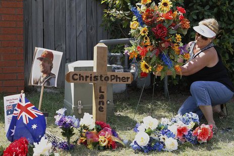 Neighborhood resident Sherrie Shannon of Duncan, Oklahoma, places flowers at a memorial at the scene where Australian college student Christ Neighborhood resident Sherrie Shannon of Duncan, Oklahoma, places flowers at a memorial at the scene where Australian college student Christ
