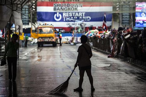 An anti-government protester cleans a street where fellow protesters are camping on a much lower scale after Sunday's general election, in B An anti-government protester cleans a street where fellow protesters are camping on a much lower scale after Sunday's general election, in B
