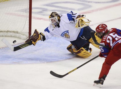 Finland's goalie Noora Raty deflects a shot on net from Russia's Yekaterina Lebedeva during the second period of their bronze medal game at Finland's goalie Noora Raty deflects a shot on net from Russia's Yekaterina Lebedeva during the second period of their bronze medal game at