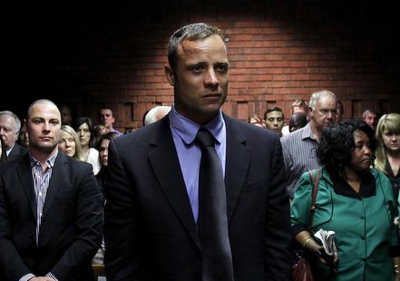 Oscar Pistorius awaits the start of court proceedings while his brother Carl (L) looks on, in the Pretoria Magistrates court February 19, 20 Oscar Pistorius awaits the start of court proceedings while his brother Carl (L) looks on, in the Pretoria Magistrates court February 19, 20